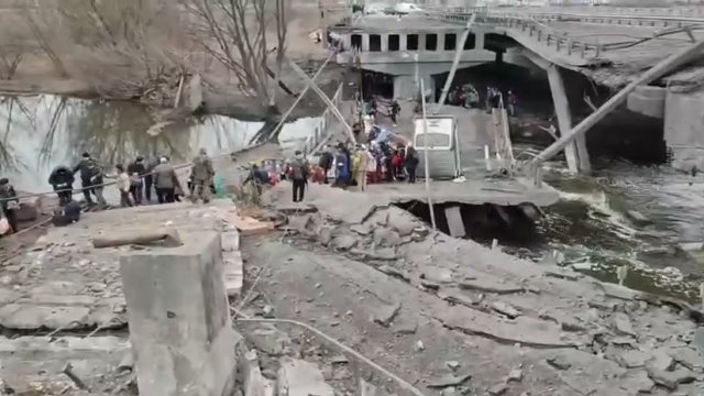 Mieszkańcy Irpień opuszczają miasto przez zniszczony most.