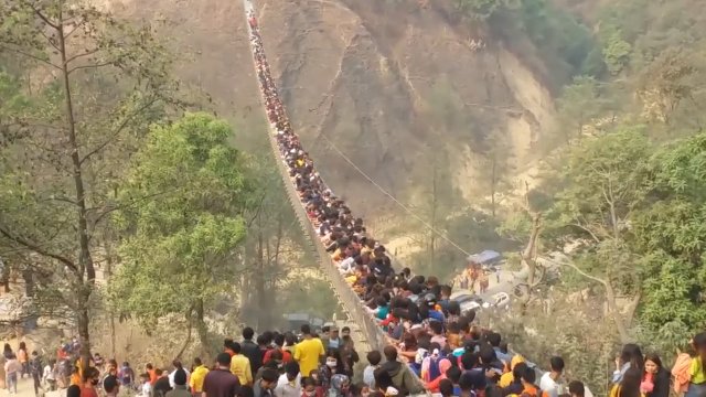 Tłumy ludzi na wiszącym moście w Nepalu