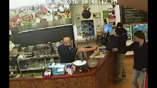 Właściciel sklepu ignoruje uzbrojonego złodzieja, aby dokończyć obsługiwanie klienta