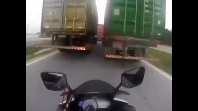 To nie miało prawa się udać – motocyklista wjechał pomiędzy dwie ciężarówki! [WIDEO]
