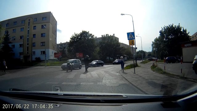 Motocyklista pomaga staruszce przejść przez przejście w Łodzi