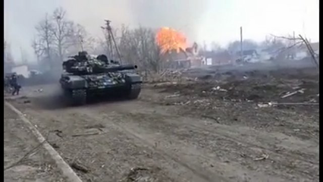 Ukraiński czołg w ruchu z potężną eksplozją w tle