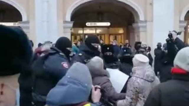 Rosyjska policja zatrzymuje starszą panią protestującą przeciwko wojnie.
