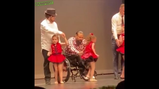 Tata na wózku inwalidzkim tańczy z córką na scenie