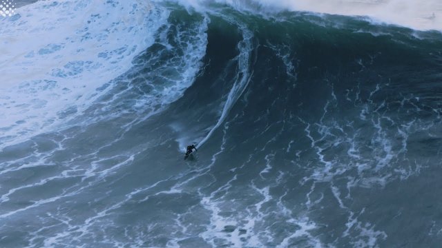 Skuter wodny podejmuje surfera przed wielką falą