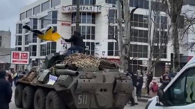 Ukrainiec wskakuje na rosyjski pojazd bojowy by machać flagą
