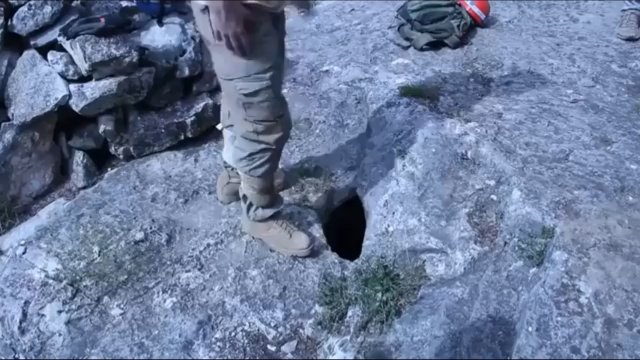Mężczyzna wchodzi przez to małe wejście, aby zbadać jaskinię