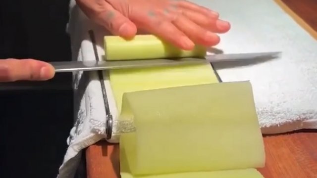 Sushi master demonstruje technikę krojenia ogórka