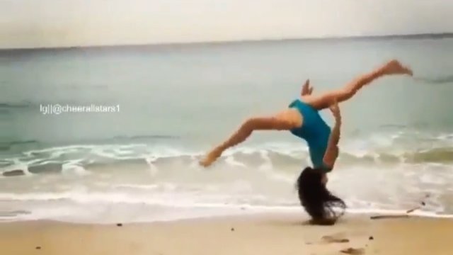 Dziewczyna w stroju kąpielowym na plaży popisuje się gibkością