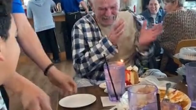 Reakcja starszego mężczyzny na tort urodzinowy