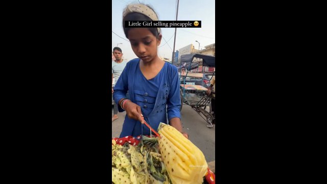 Młoda dziewczynka zajmuje się sprzedażą ananasów
