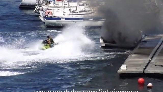 Koleś na skuterze wodnym, kręcąc bączki gasi pożar łodzi