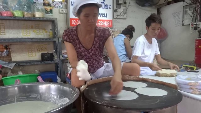 Kobieta w szybkim tempie przygotowuje papier ryżowy