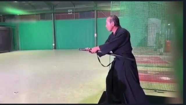 Samuraj przecina piłkę za pomocą katany