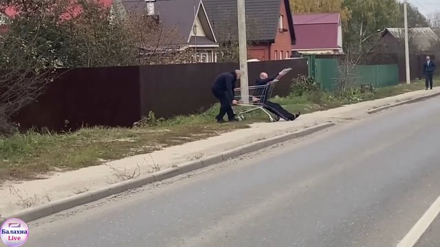 Mężczyzna dostarcza swojego pijanego przyjaciela do domu wózkiem na zakupy