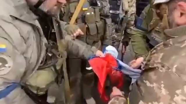 Gruzińscy legioniści i ukraińscy żołnierze palą rosyjską flagę