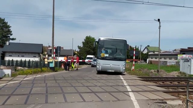 Autobus z dziećmi przejeżdża przez zamknięty przejazd kolejowy