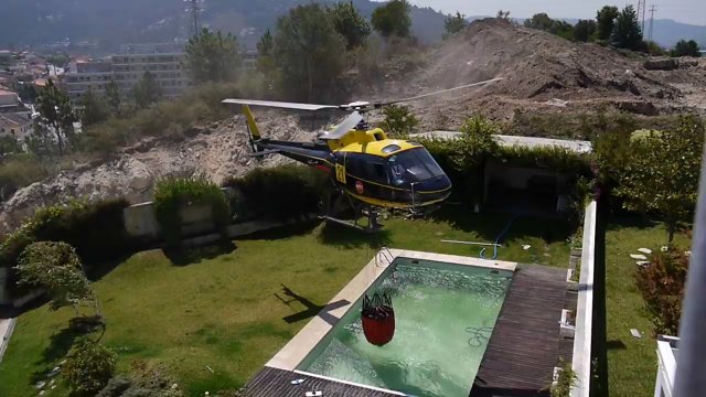 Pilot śmigłowca pożycza wodę z basenu