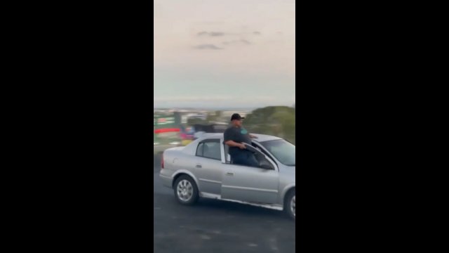 Facet wychyla się z jadącego samochodu, aby zaimponować tłumowi