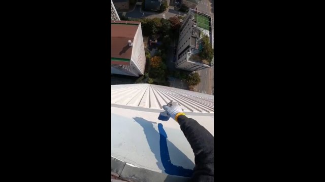 Ryzykowane malowanie ściany wysokiego budynku