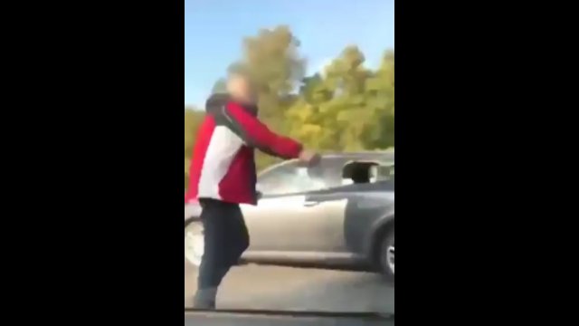 Idiota zaczął walczyć z samochodem na środku ruchliwej drogi [WIDEO]