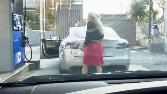Kobieta próbuje zatankować... elektryczny samochód.