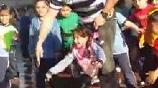 Nauczyciel WF pomaga małej dziewczynki z niepełnosprawnością dołączyć do tańca