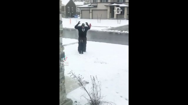 Tatuś próbuje nauczyć syna jak robić aniołki w śniegu