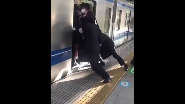 Tłok w japońskim pociągu. Facet upycha ludzi, żeby wszyscy się zmieścili