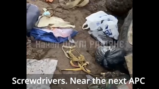 Ukraiński żołnierz przegląda przechwycony rosyjski transporter ze zrabowanymi towarami