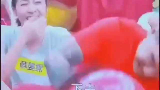 Tajwan - teleturniej rodzinny pomocny mąż pomaga żonie przebić balon głową.