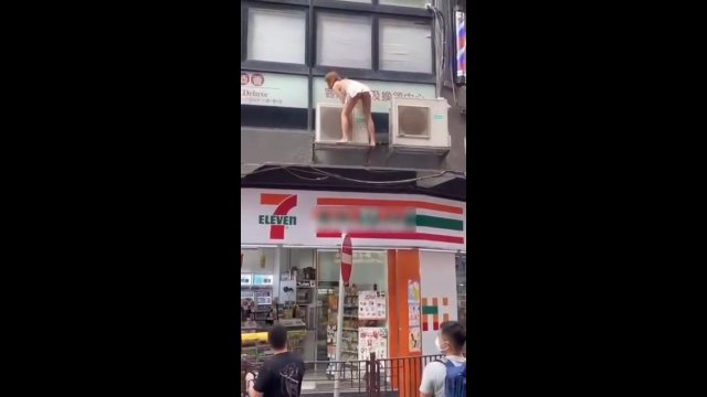 Kobieta schodzi z budynku w Hongkongu, by uciec gliniarzom