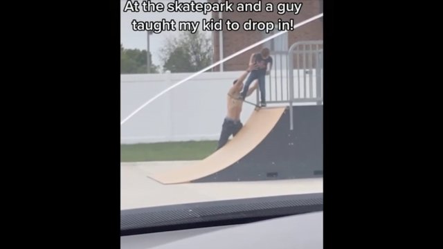 Tata skater uczy dziecko w jaki sposób zjechać z rampy