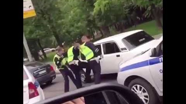Policjanci próbują wyciągnąć gościa ze starej Łady