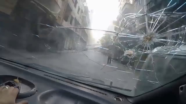 Przejazd samochodem w trakcie bombardowania pociskami kasetowymi. Douma, Syria listopad 2017 r.