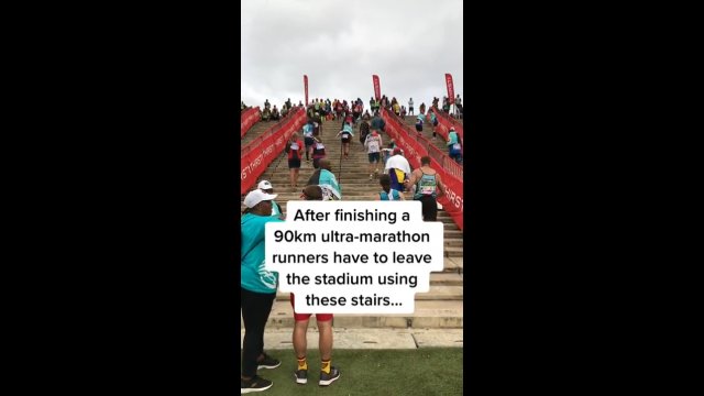 Po ukończeniu 90km ultra-maratonu biegacze opuszczają stadion używając schodów