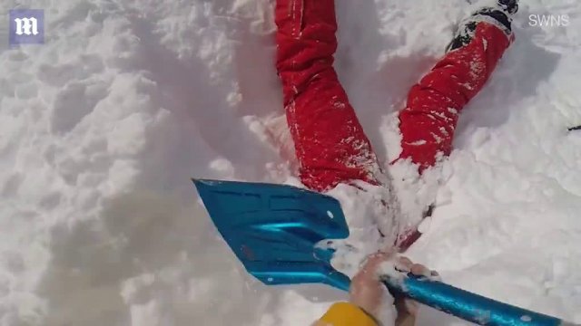 Narciarz natyka się na nogi wystające ze śniegu.